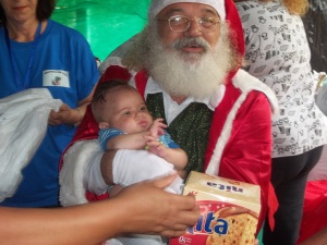 Papai Noel presenteou com sacolinhas e panetone, cada criança